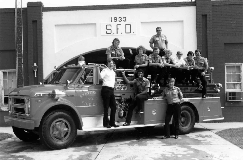 aged photo of past station, crew and truck 